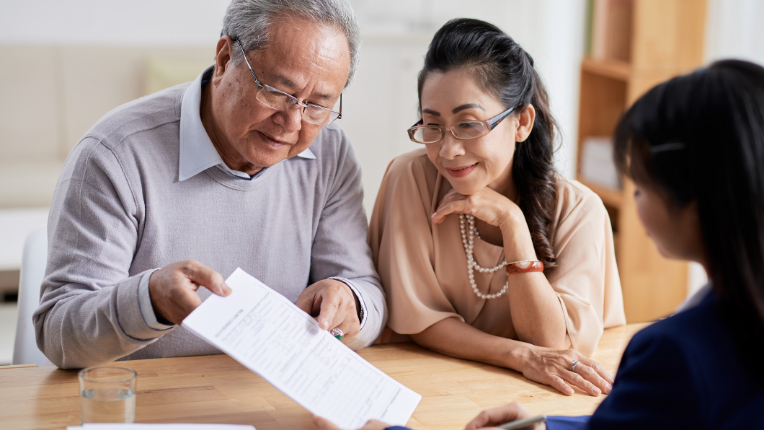 Un couple qui regarde un plan successoral avec leur conseiller en placement